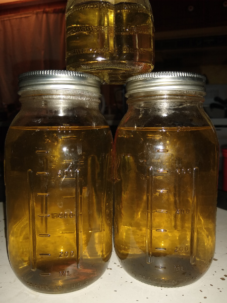 3 glass jars full of a pale golden liquid